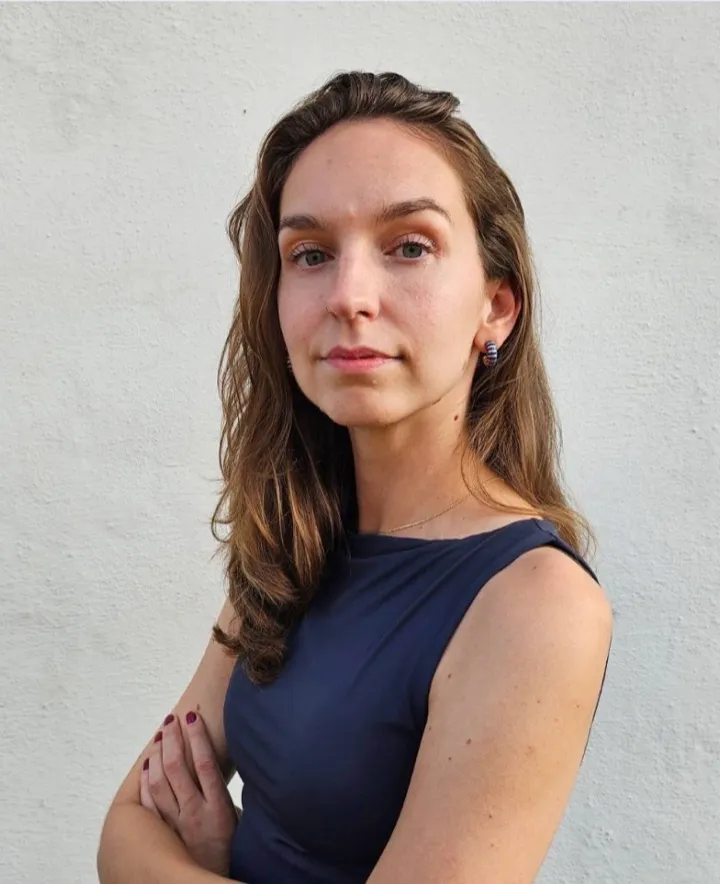 Roberta, the illustrator behind Form & Function Studios, against a white studio wall.